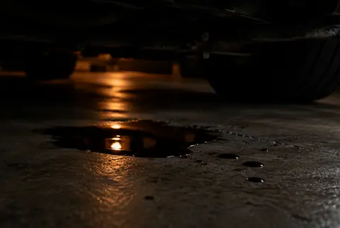 Drops of fluid on a garage floor under a car