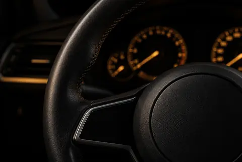 A steering wheel in a dark car cabin